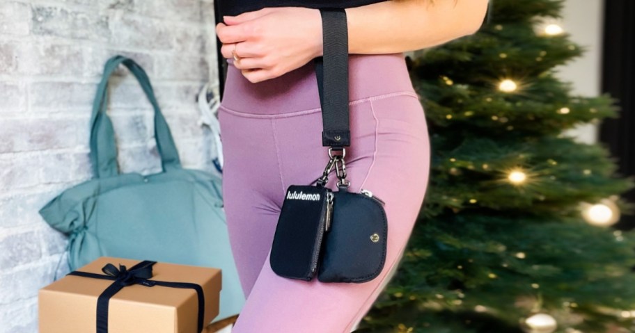 woman holding black wristlet on arm