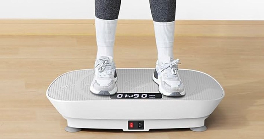 person standing on white exercise vibration plate machine 