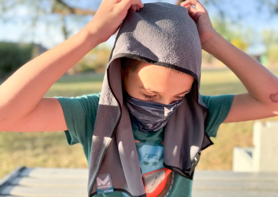 boy holding cooling towel on head