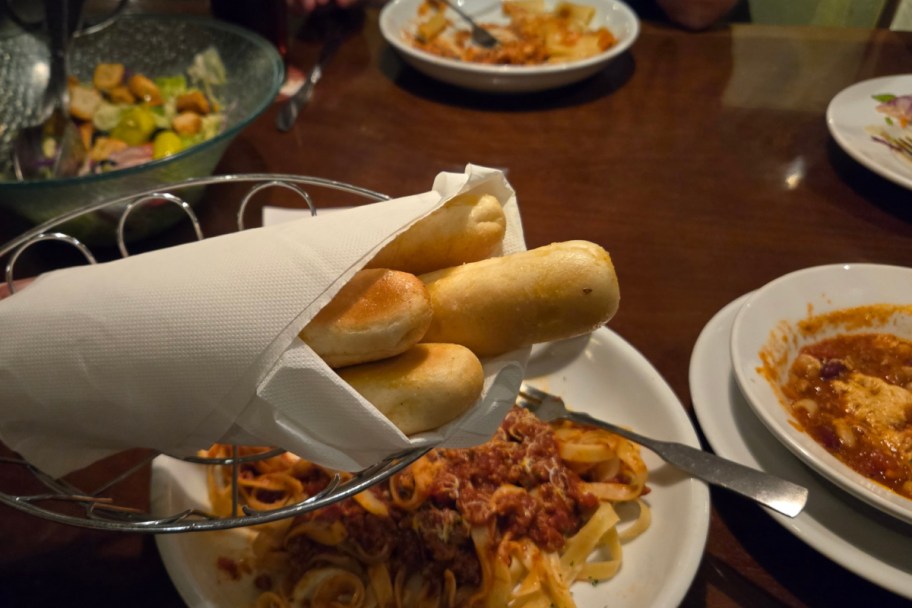 breadsticks in front of pasta bowls