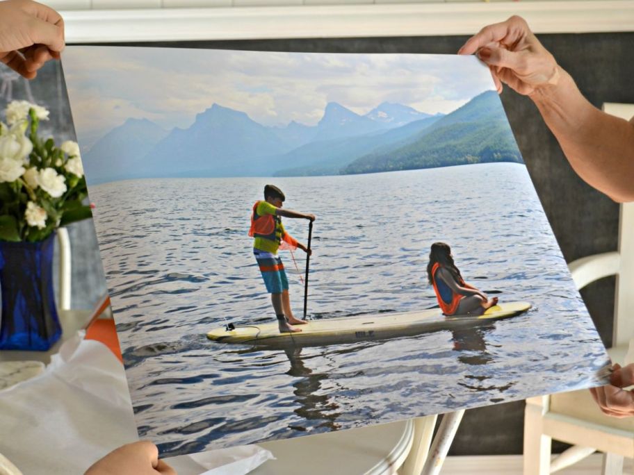 two people's hands holding the corners of a repositionable poster