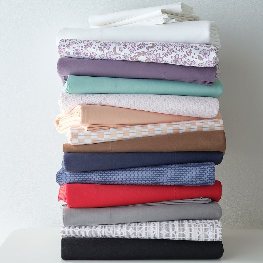 a stack of bed sheet in various colors and prints