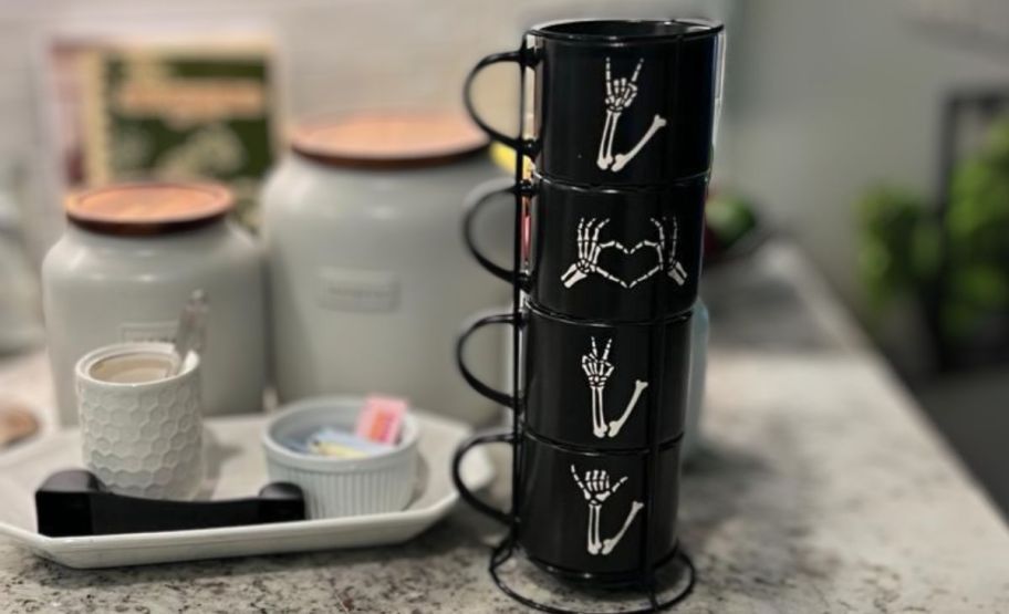 skelly hand stacking mugs on a kitchen counter