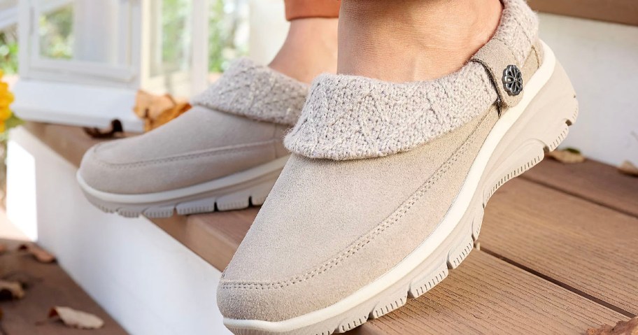 person wearing tan suede clogs on stairs