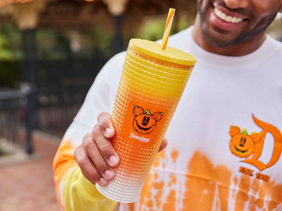 man holding mickey candy corn tumbler