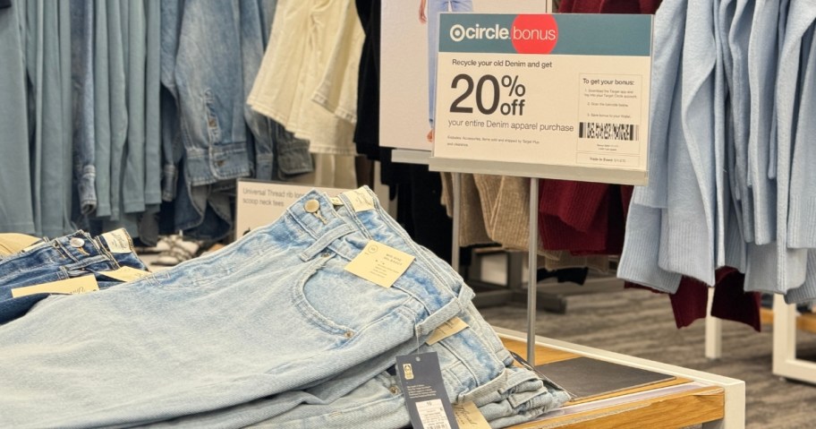 pairs of blue jeans on a display table at Target next to a sign that says 