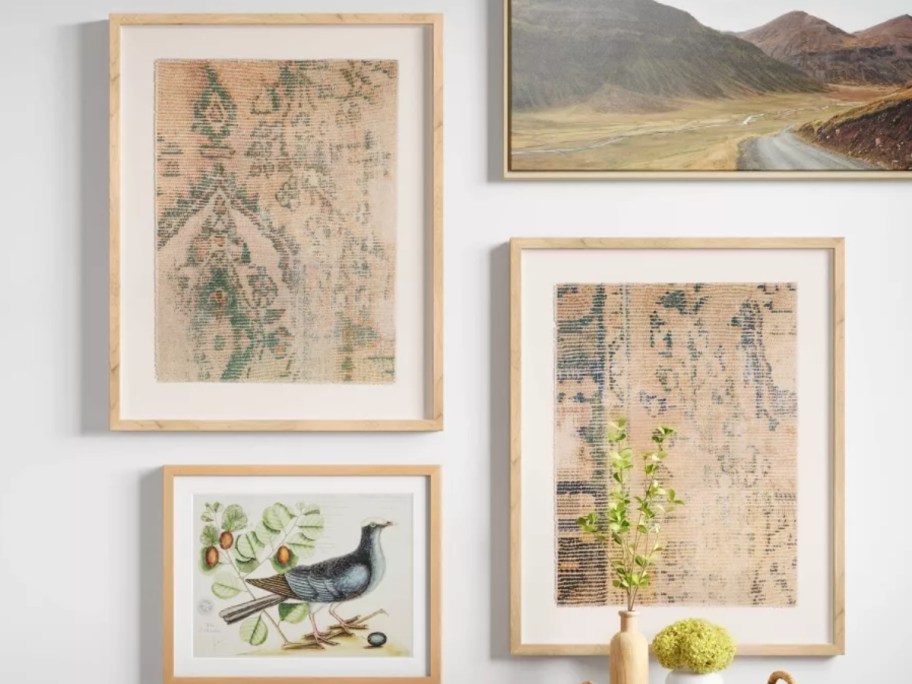 two farmed wall art pieces with textured print fabric on a wall with other art