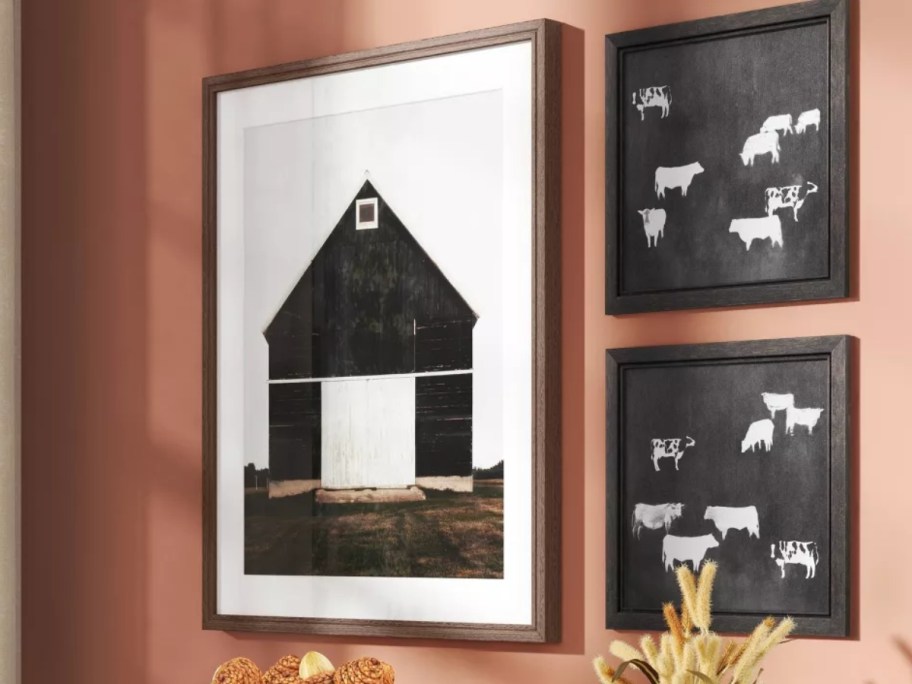 a wall with a framed art piece with a barn on it
