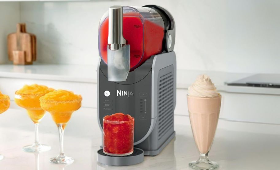 a ninja slushie is machine shown with glasses of frozen drinks. 