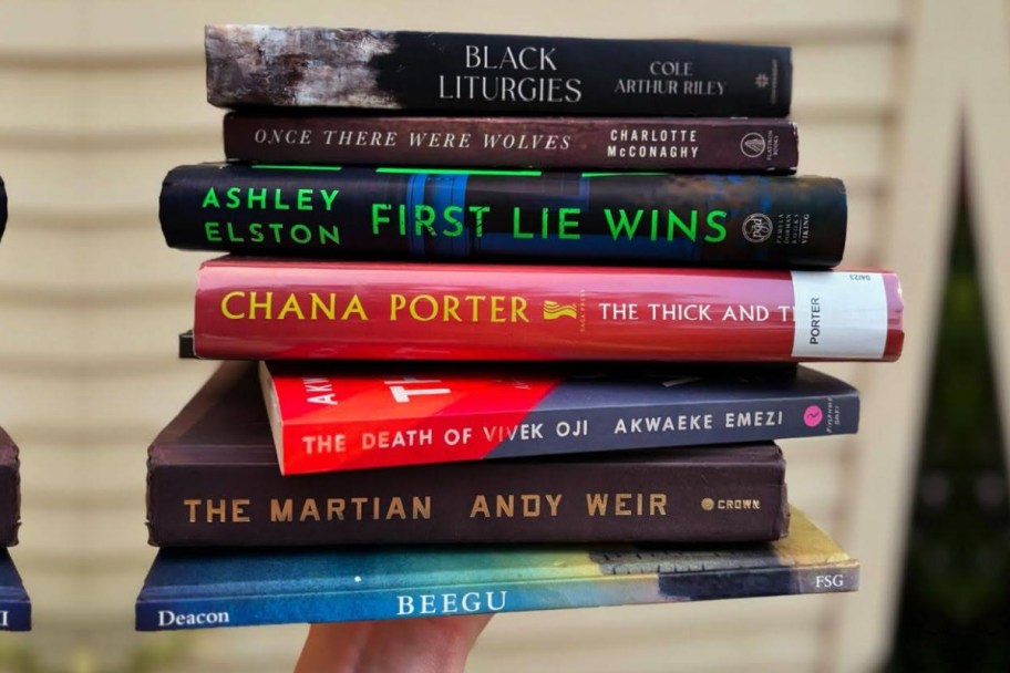 hand holding stack of books