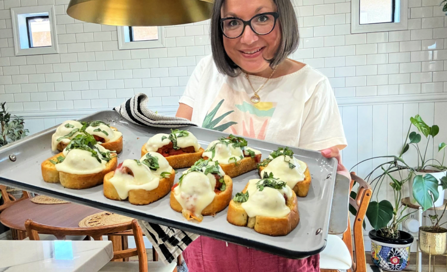 woman holding sheet pan with texas toast and meatballs
