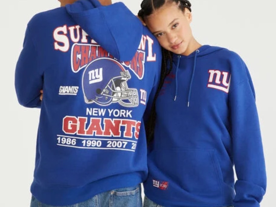 man and woman wearing blue NY Giants hoodies