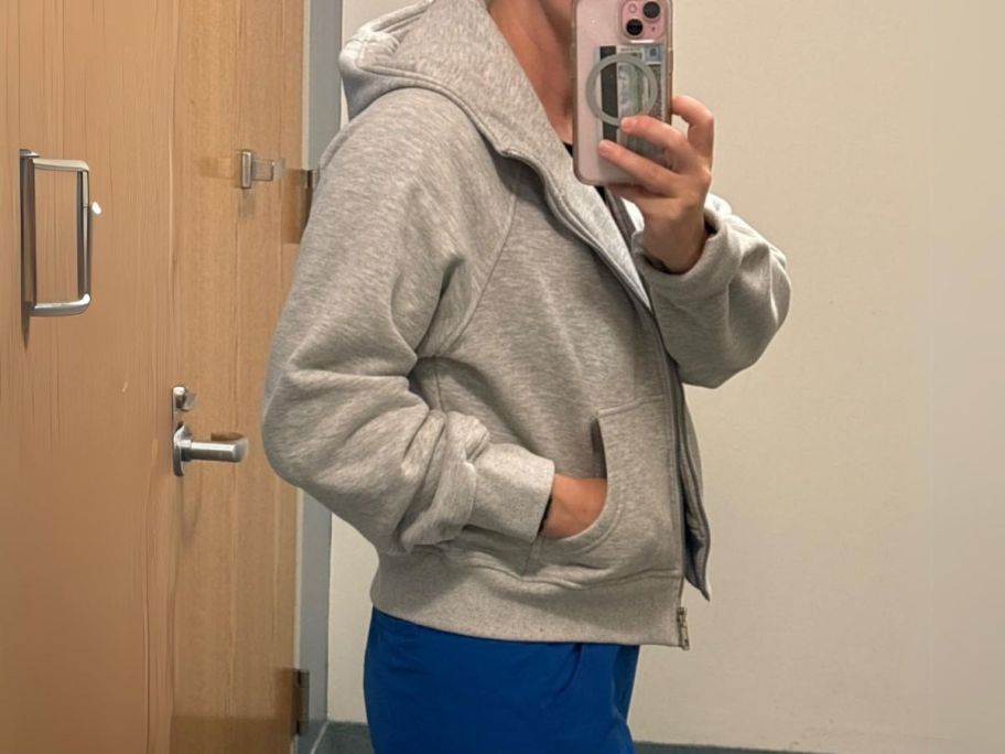 girl wearing AUTOMET Women's Zip-Up Fleece Hoodie and taking selfie from the side
