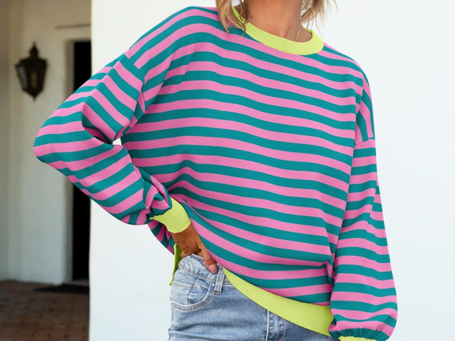 woman wearing a pink and teal striped long sleeve shirt