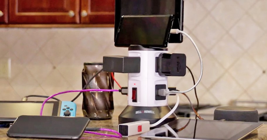 multiple devices plugged into a charging tower on a kitchen counter