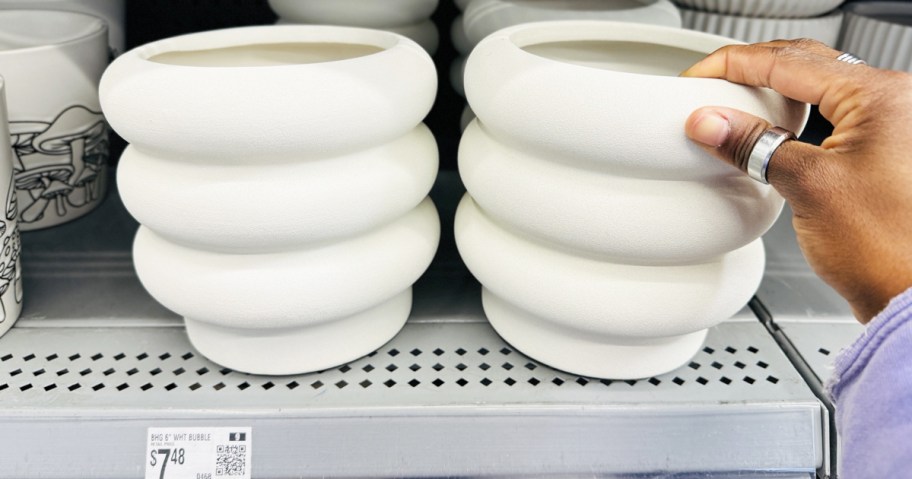 hand touching white bubble planters on store shelf