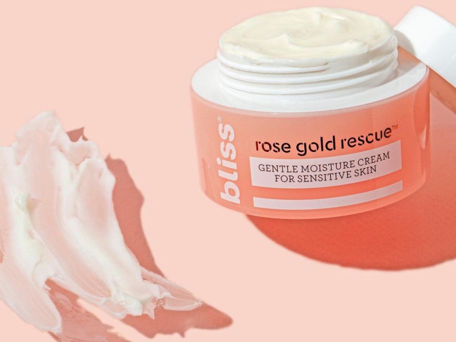 An open Jar of Bliss Rose Gold Sensitive Skin Moisturizer next to a shmear of product