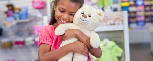 Girl hugging a build a bear for national teddy bear day