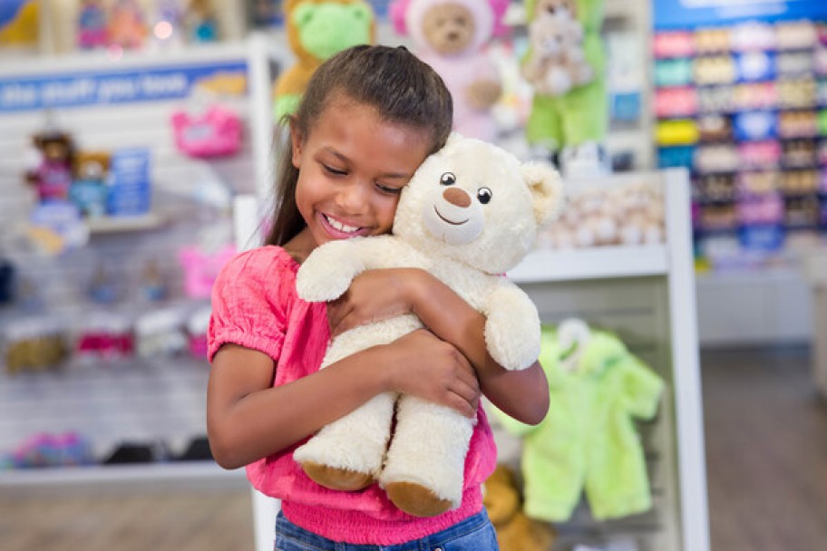 Girl hugging a build a bear for national teddy bear day