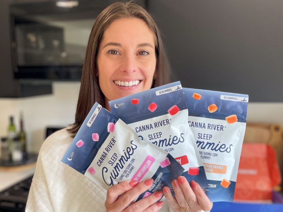 Woman holding 3 bags of Canna River Gummies