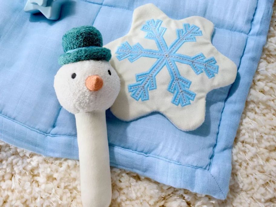 Cloud Island Snowman Soft Rattle + Snowflake Crinkle Paper on rug