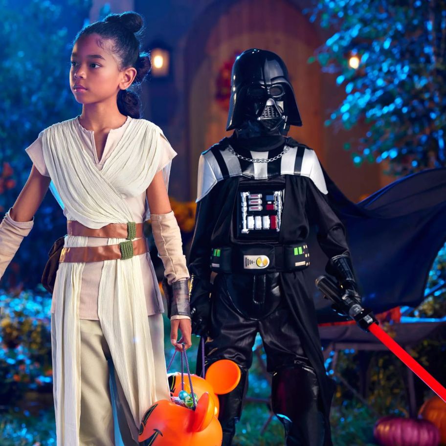 a little girl in a Rey costume and a little boy in a darth vader costume