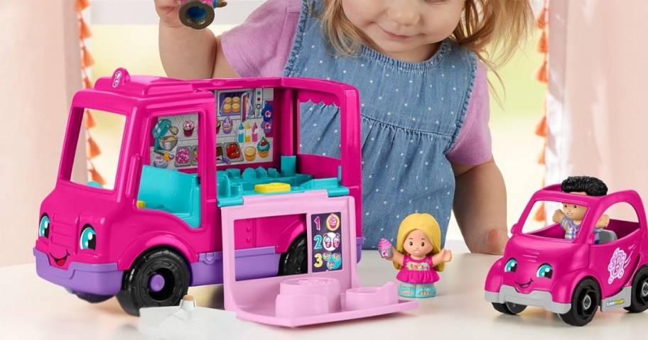 little girl playing with a pink Fisher-Price Little People Barbie Toddler Toy Cupcake Food Truck and car 