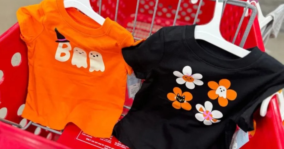 kid's Halloween tshirts in a Target cart, one orange with Boo Ghosts and one black with Halloween Flowers