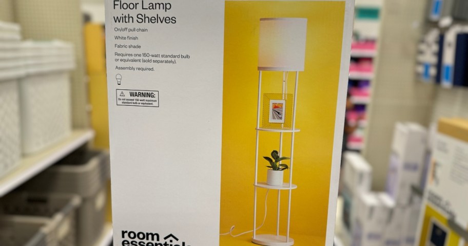 hand holding up a box with a white floor lamp with shelves pictured on it