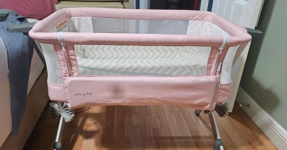 pink baby bassinet with white mesh sides