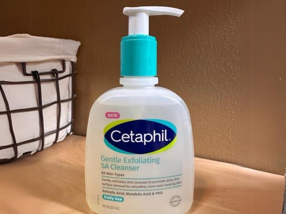 bottle of Cetaphil Gentle Exfoliating SA Cleanser on a wood counter, basket in the background