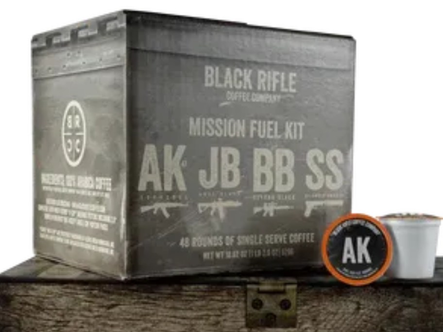 large box of Black Rifle Company Mixed Coffee Rounds K-Cups with 2 k-cups in front, setting on top of a wooden crate