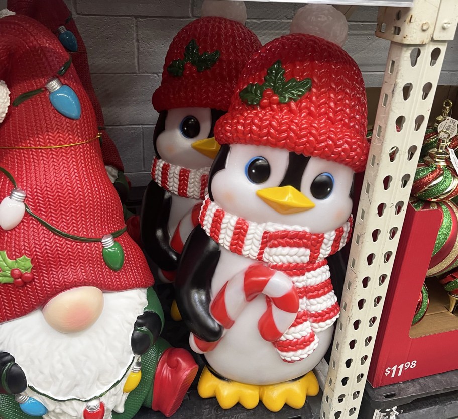 penguin holding a candy cane blow mold on store shelf