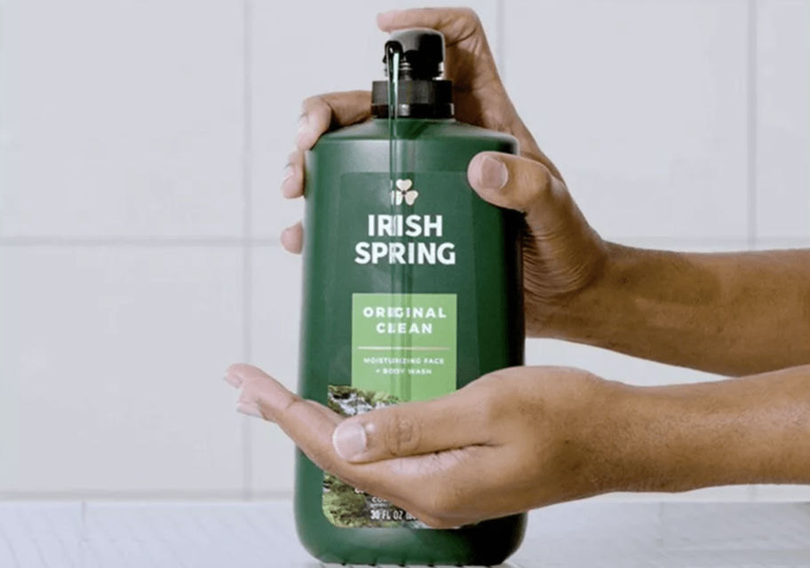 hands holding a body wash with some dispensing