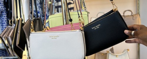 white and black kate spade crossbody bags on display in store