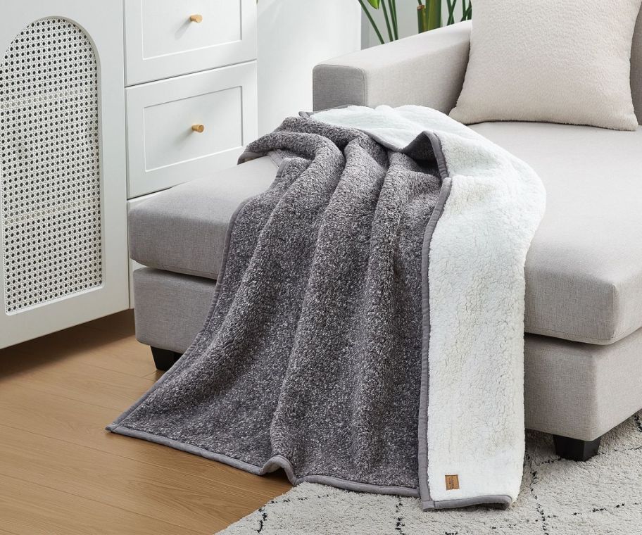 a gray textured throw blanket on a chaise