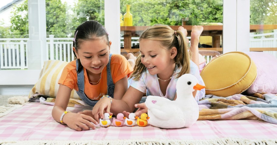 2 girls playing with Pets Alive Mama Duck & Baby Surprise toy on the floor