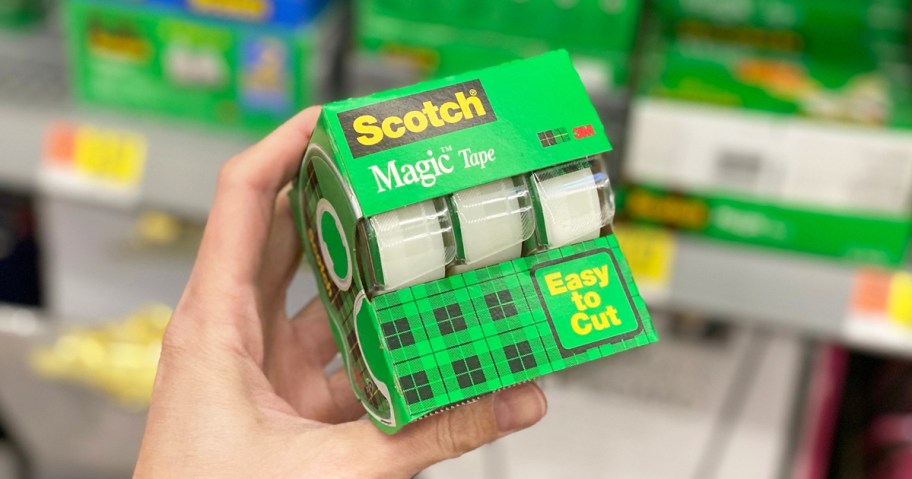 hand holding a green 3-pack of scotch tape