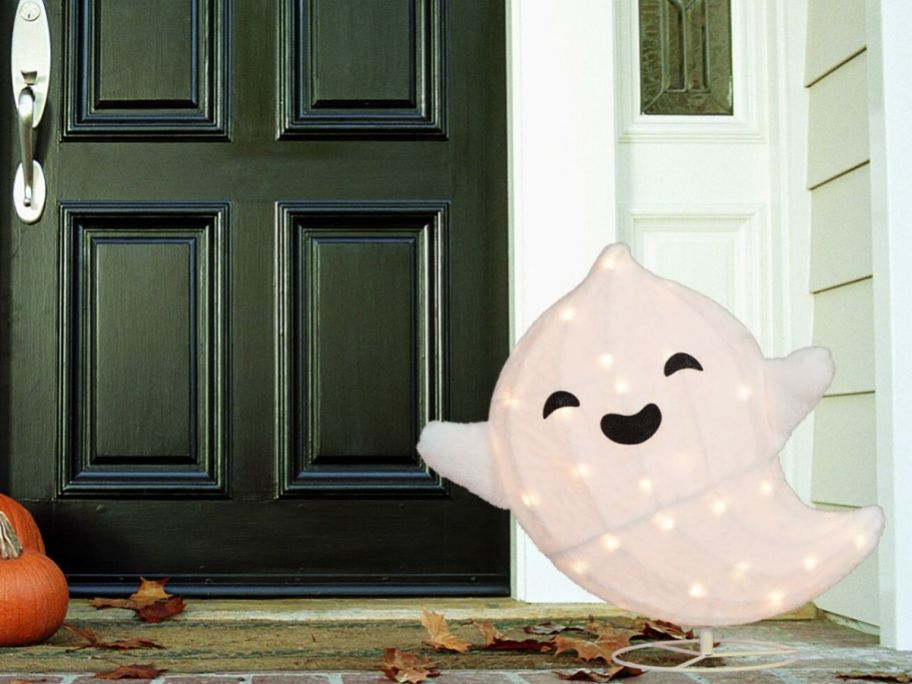 A smiling Halloween ghost outside a house