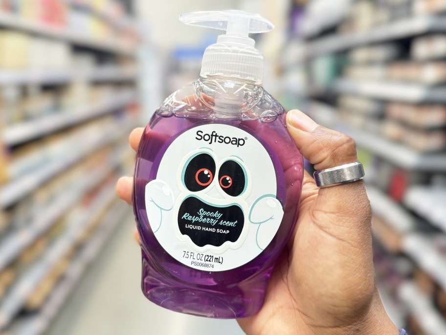 hand holding up a purple bottle of Halloween Softsoap hand soap