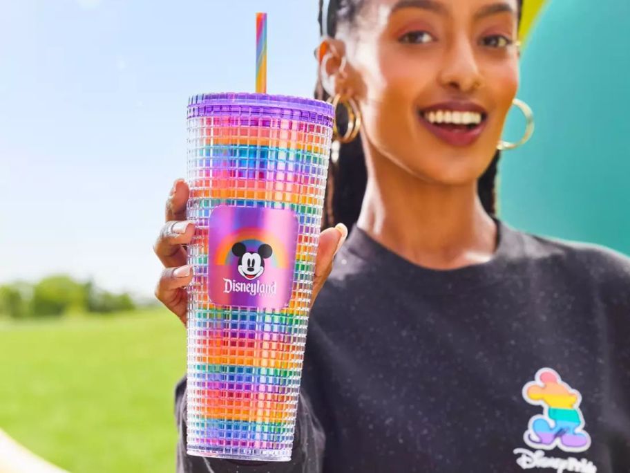 Woman holding a rainbow colored Starbucks Disney Tumbler