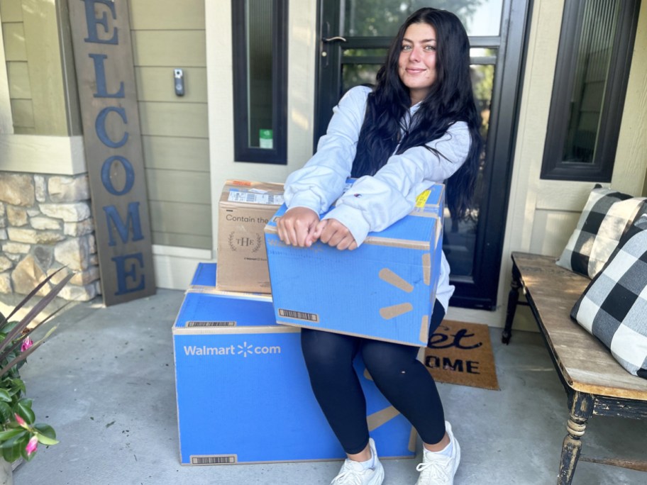 teen girl siting on porch with lots of walmart boxes
