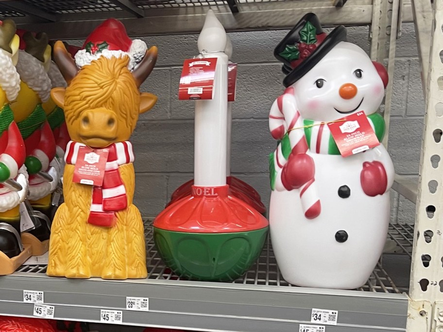 highland cow, candle, and snowman christmas blow molds on store shelf