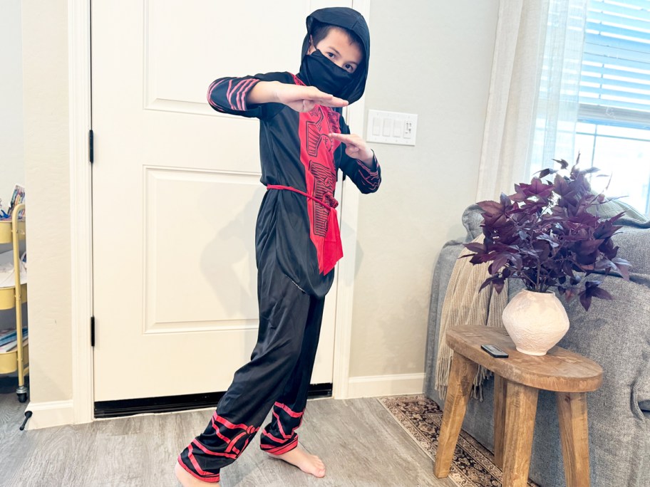 boy in a red and black ninja halloween costume