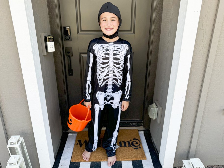 boy in a skeleton halloween costume near front door