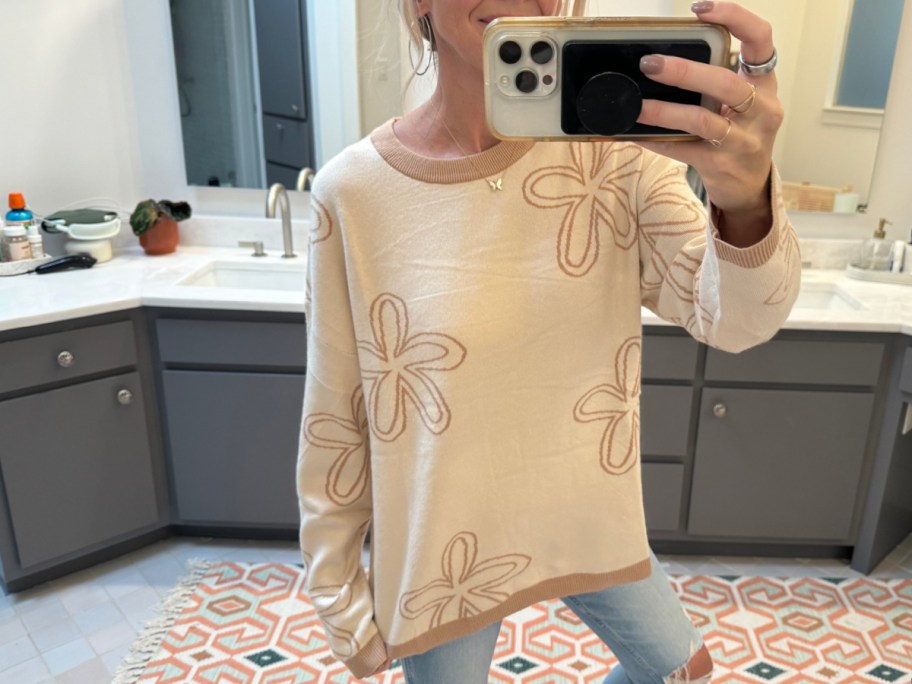 Woman wearing flower sweater in beige and brown in her bathroom