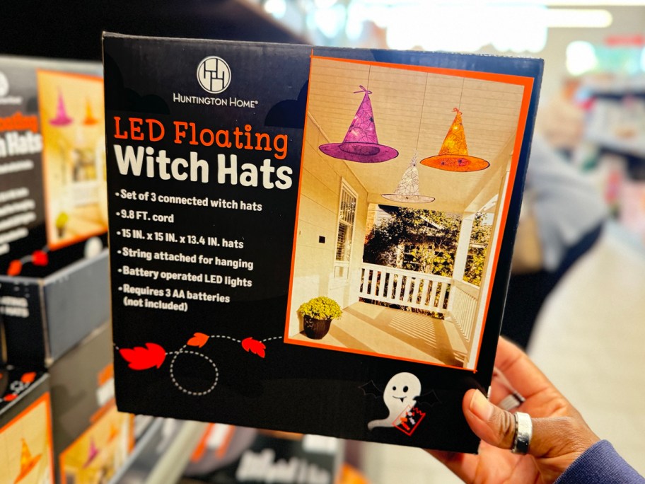 hand holding floating witch hats box