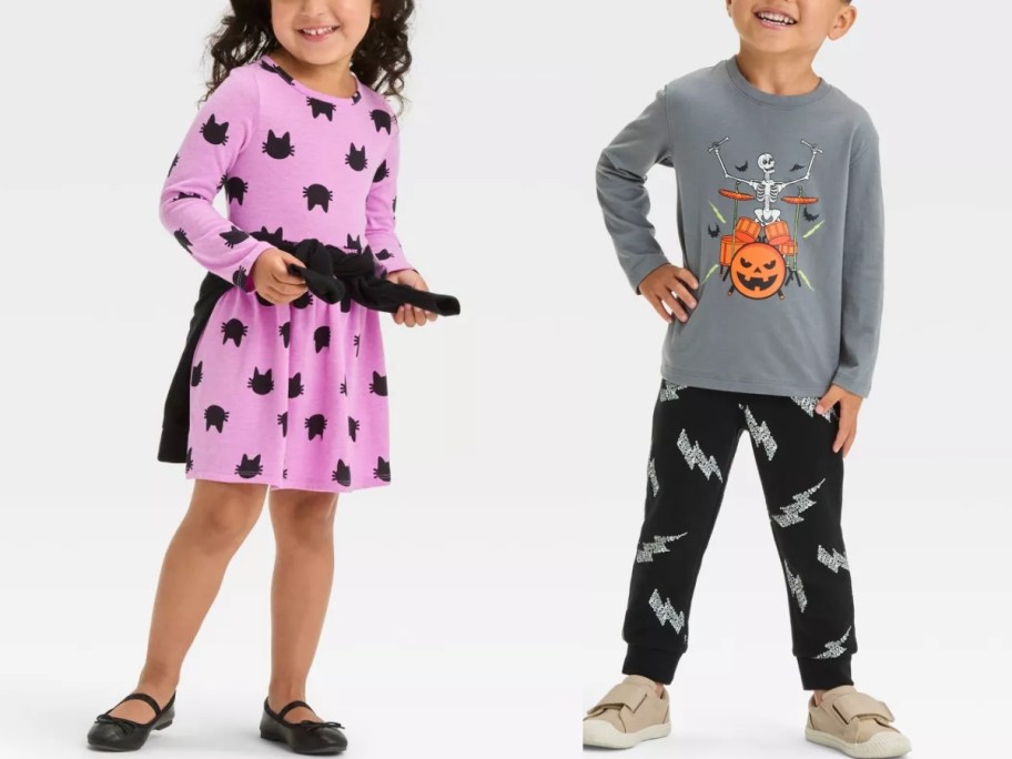 little girl wearing a light purple dress with bats on it and little boy wearing a Halloween long sleeve shirt and matching jogger pants