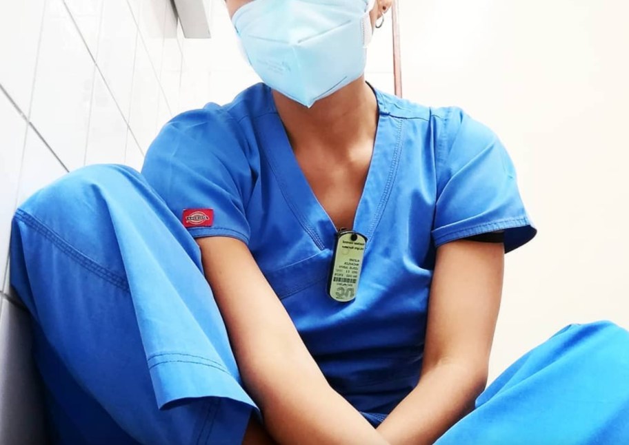 woman with face mask wearing blue scrubs