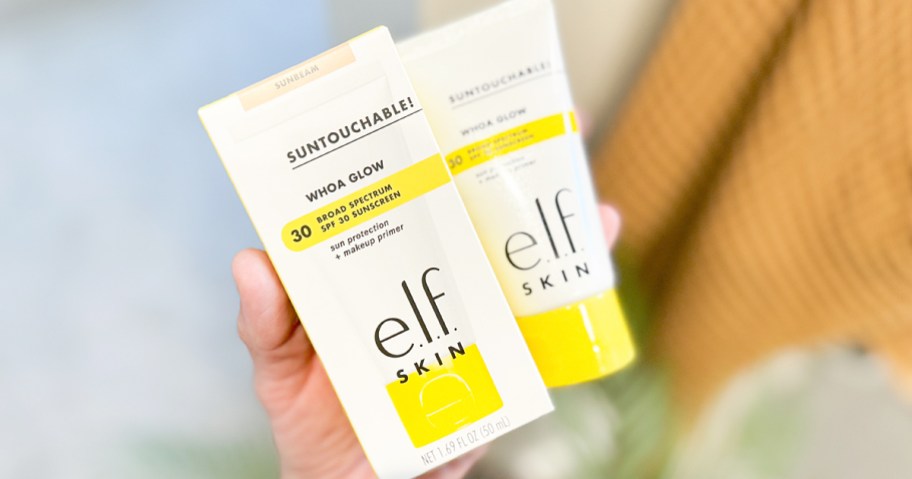 hand holding box and tube of e.l.f. Suntouchable Whoa Glow SPF 30 Sunscreen